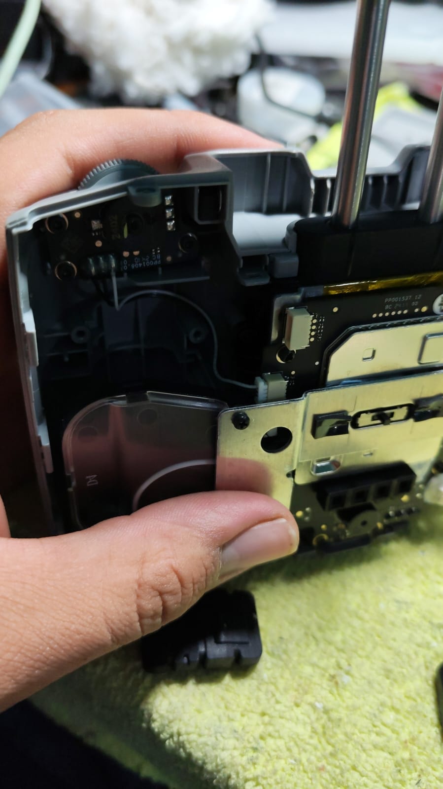Interior de drone DJI abierto mostrando placa madre y módulo GPS en reparación